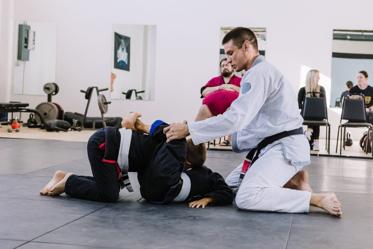 Professor Matt Vernon of Primate Jiu Jitsu in Tulsa OK offers instruction during kids BJJ classes while parents look on