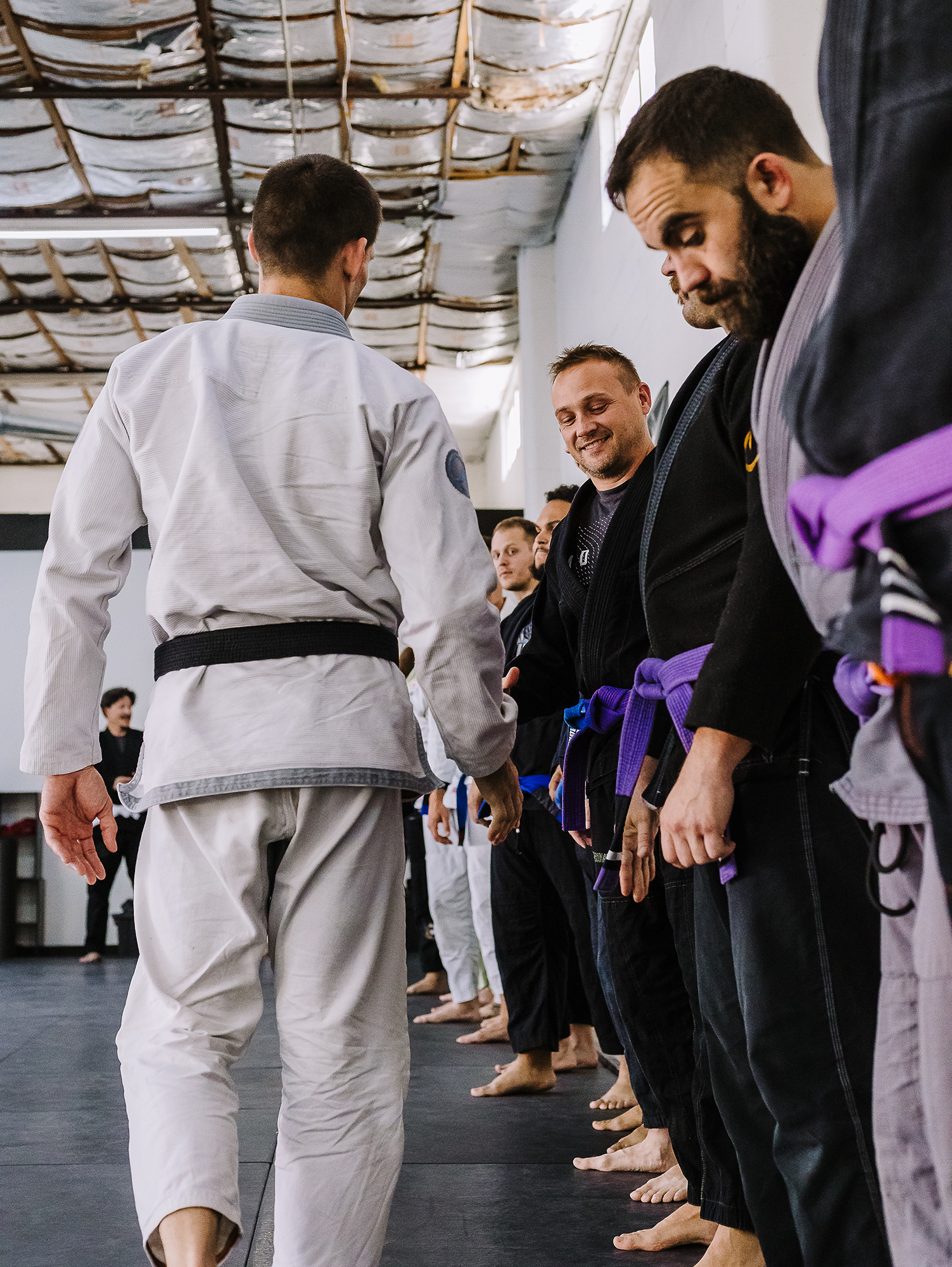 Black belt professor Matt Vernon shakes hands with his students before beginning adult BJJ class at Primate Jiu Jitsu in Tulsa OK